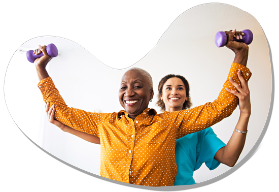 Elderly woman lifting weights with help from caregiver