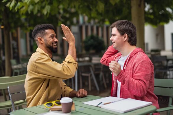 A caregiver and a young man high-five.