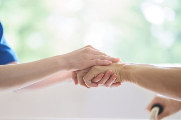 A Caregiver Holding A Patient’s Hand Compassionately 