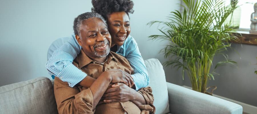 Daughter hugging father on sofa