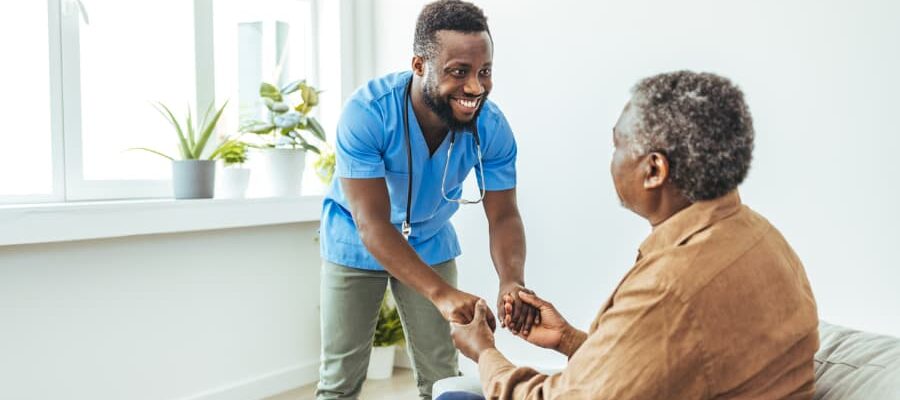 Healthcare worker holding hands of senior male patient