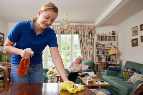 Caregiver cleaning table with senior in the background