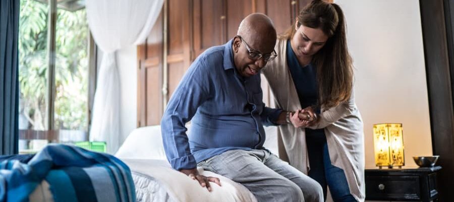 Caregiver helping a person out of bed