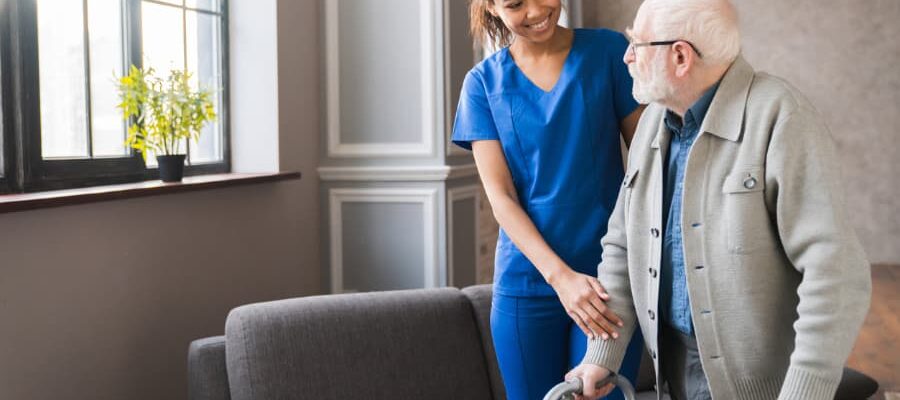 Caregiver helping elderly person with walker