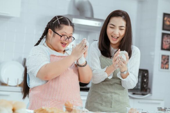 Adult and child in kitchen cooking and laughing