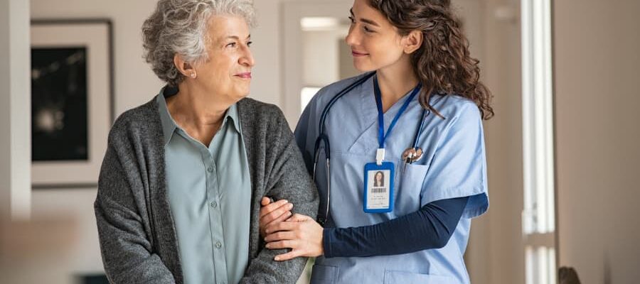 Caregiver with a woman walking in a home hallway