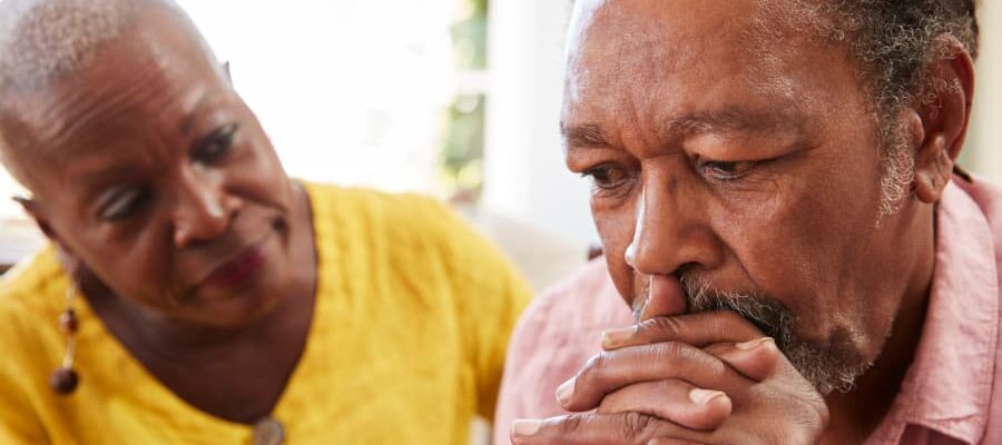 Senior woman consoling older man