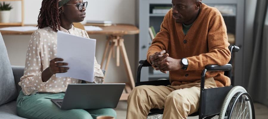 A person living with disability talks to his in-home caregiver about habilitation services