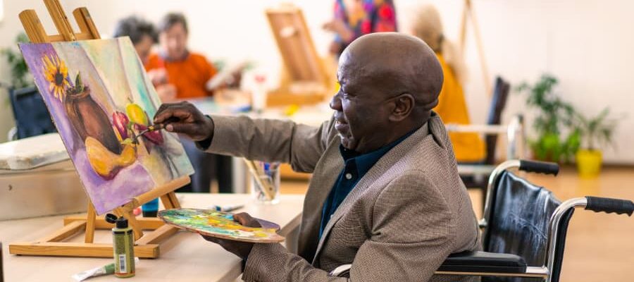 A person in a wheelchair paints in art class