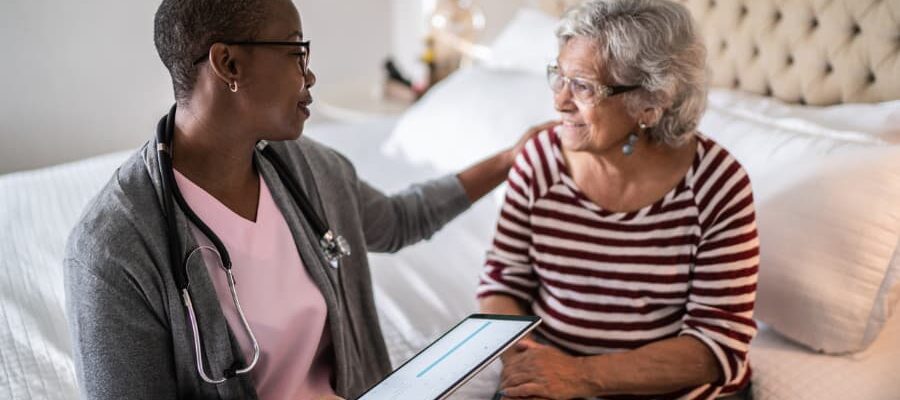 Nurse talking to resident sitting on bed