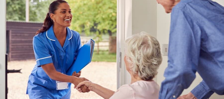 Smiling caregiver shaking hands with person using a wheelchair