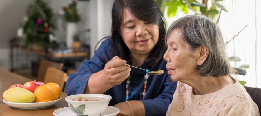 Family caregiver helping family member eat