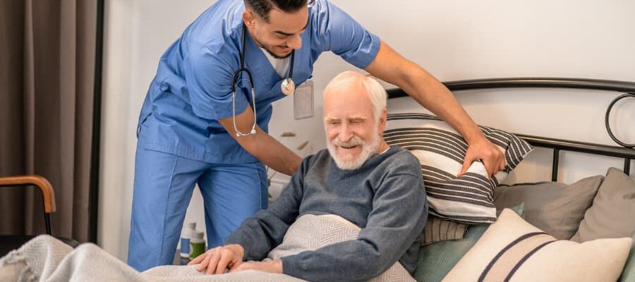 Overnight caregiver adjusting patient’s pillow before bed for a good night’s sleep