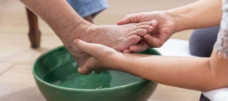 Caregiver inspecting person’s toenails